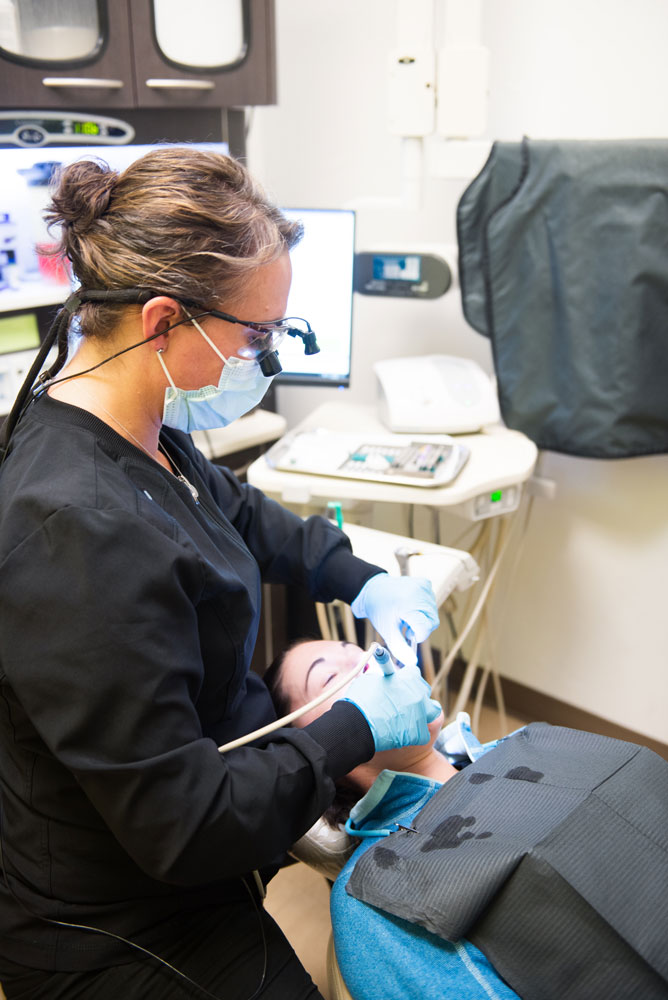 hygienist cleaning patients teeth