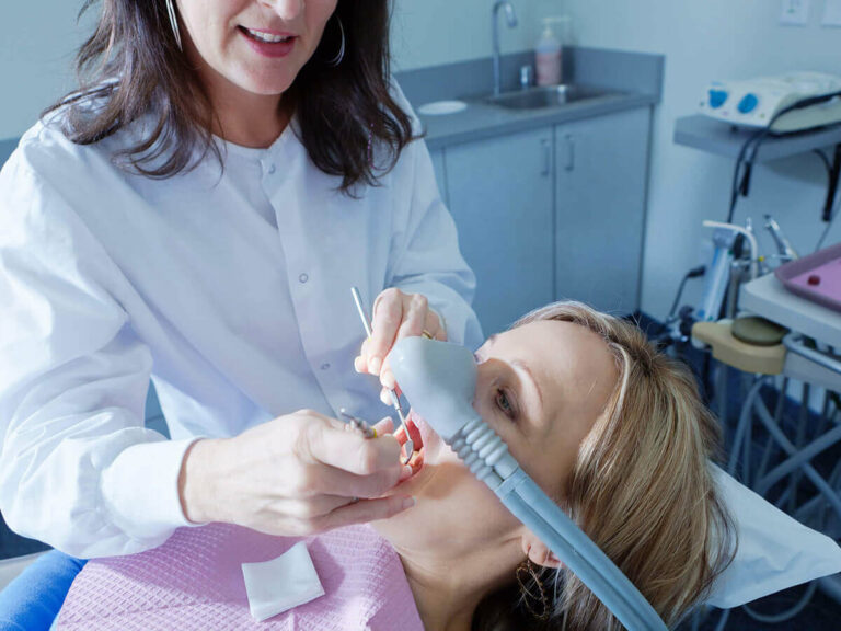 dentist checking patients teeth with pick and mirror