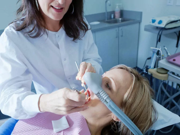 dentist checking patients teeth with pick and mirror