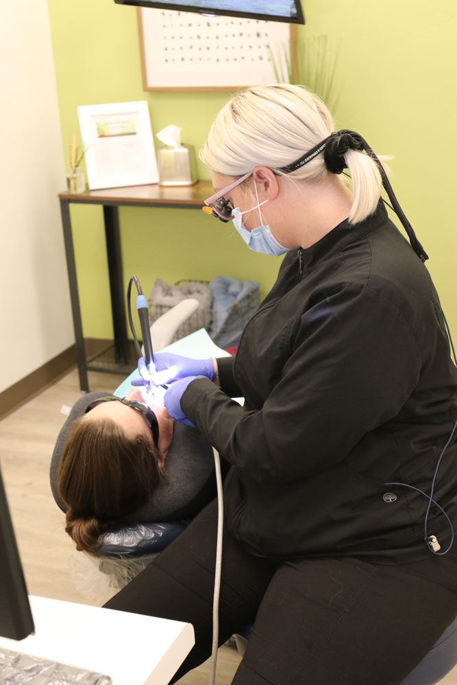 hygienist cleaning patients teeth