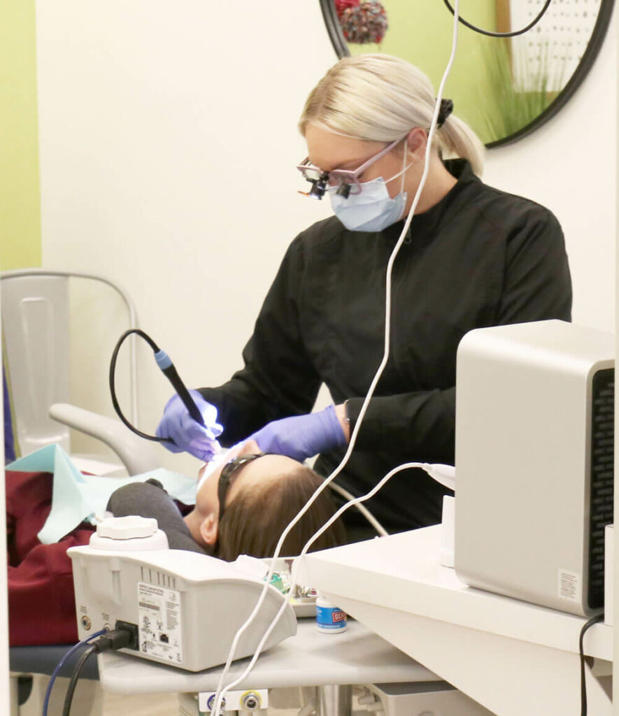 hygienist cleaning patients teeth