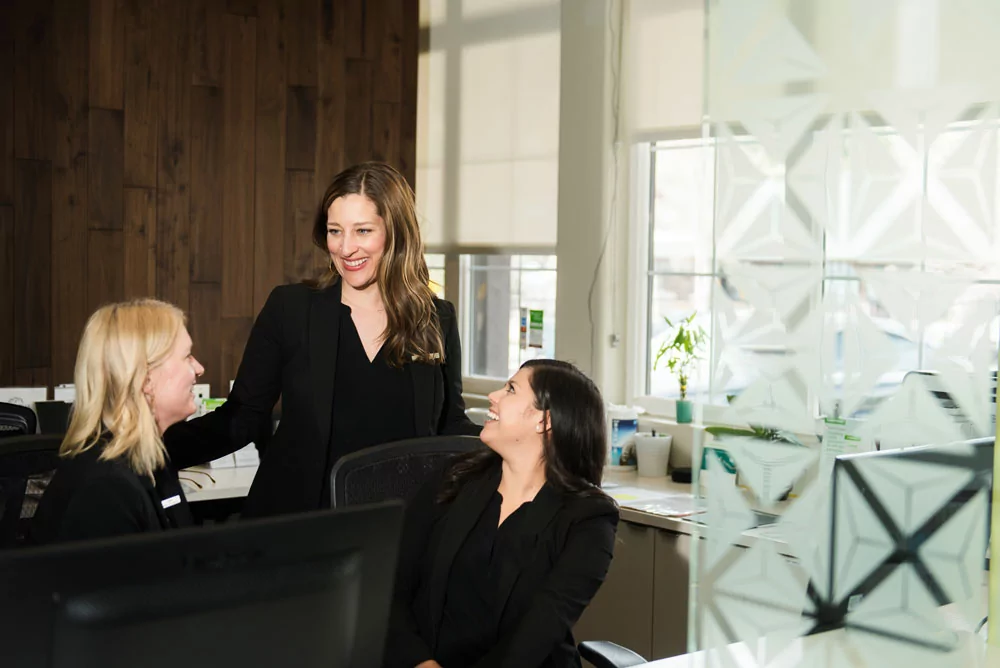 three girls smiling at one another