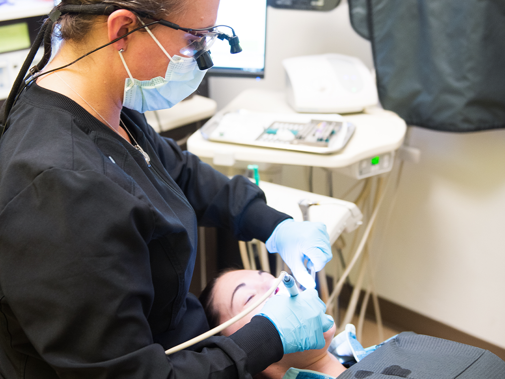 hygienist cleaning patients teeth