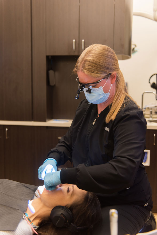 hygienist cleaning patients teeth