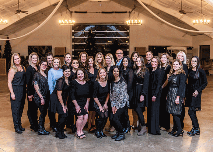 Group photo of the entire Castle Peak Dental staff, around 20 people, dressed in nice clothes.